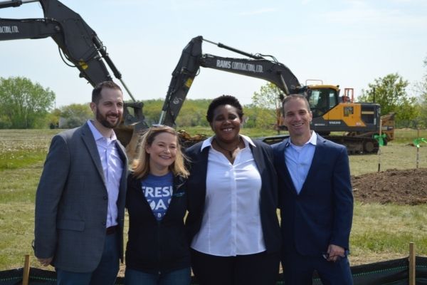 four people standing in front of construction site