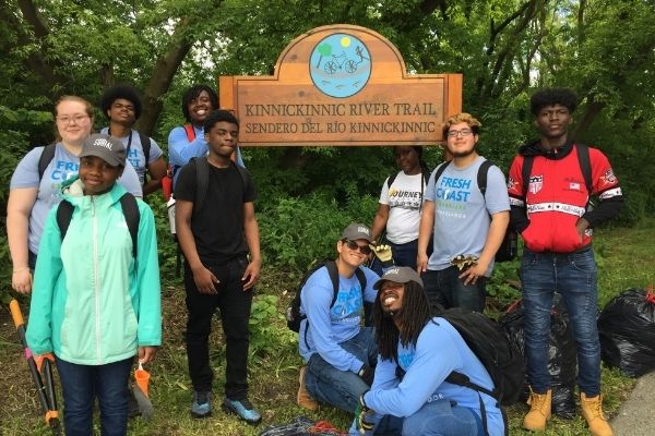 students around a sign in a park